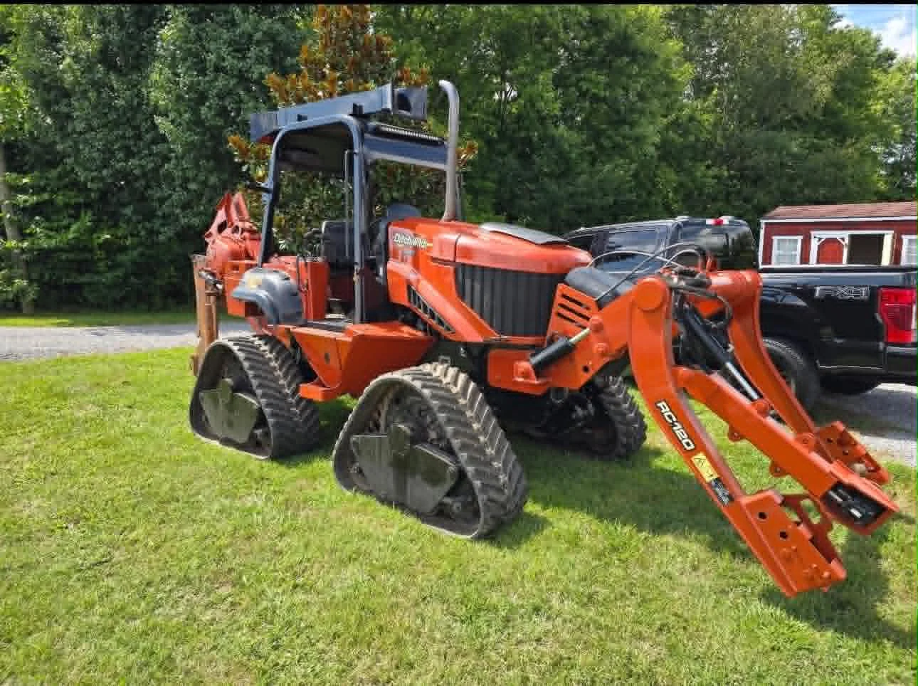 Ditch Witch RC120 rubber-track tractor with backhoe on the West Coral Communications yard